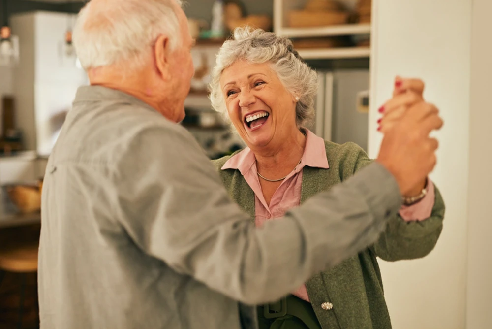 Un Uomo e una Donna che ballano sorridenti in un momento di convivialità presso Rodevita Home